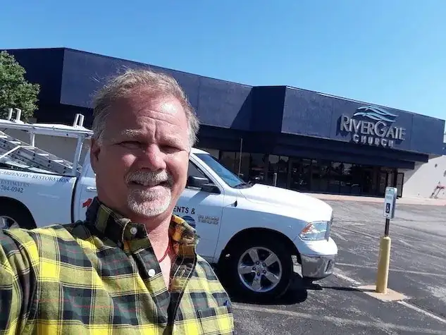 Mike Ross, owner of Oklahoma Siding, in a selfie standing beside his work truck