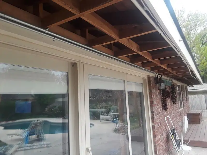 Open soffit framing over patio doors with a pool visible below