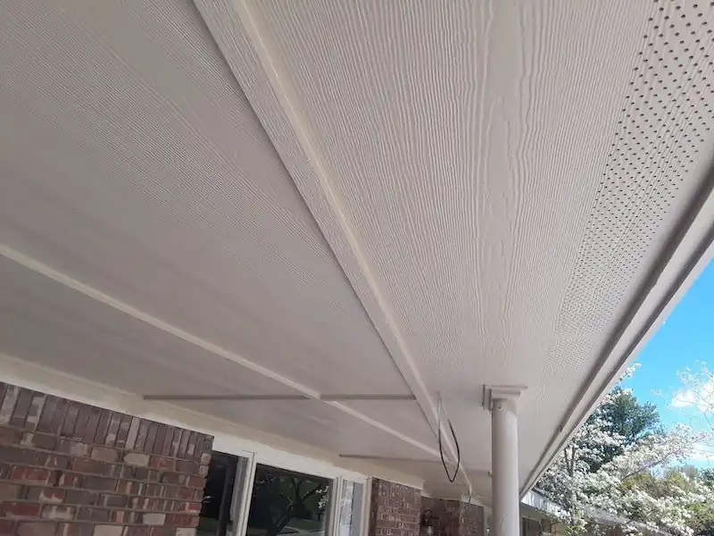 Finished vented soffit panels under the roof edge of a house